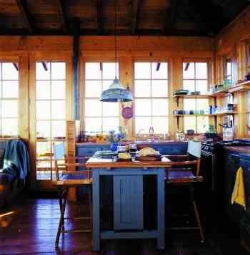 
In the kitchen, a shorter chest-style refrigerator, painted to match the cabinets, allows 360-degree views of the Cascade and Ochoco Mountains. The countertops are milled from a large Douglas fir log washed up on the shore of Whidbey Island.
